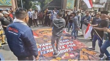 AMI Lempar Telur Busuk ke Spanduk Bergambar Febrie Adriansyah di Depan Kejati Jatim